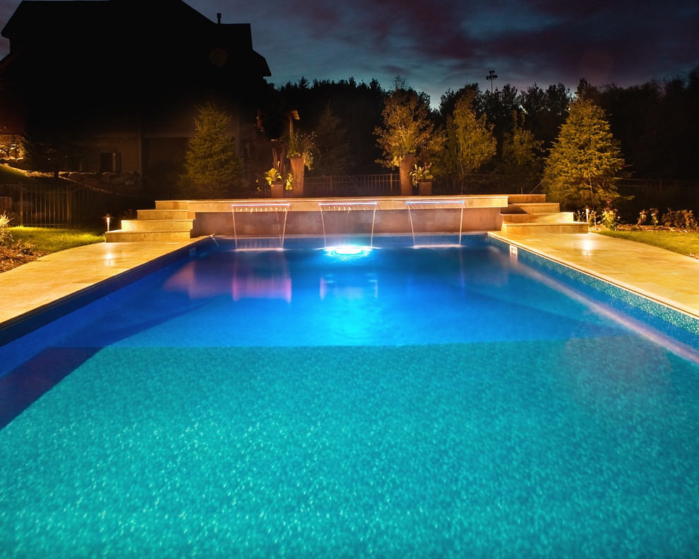 Example of a trendy backyard stone and rectangular pool fountain design in Minneapolis