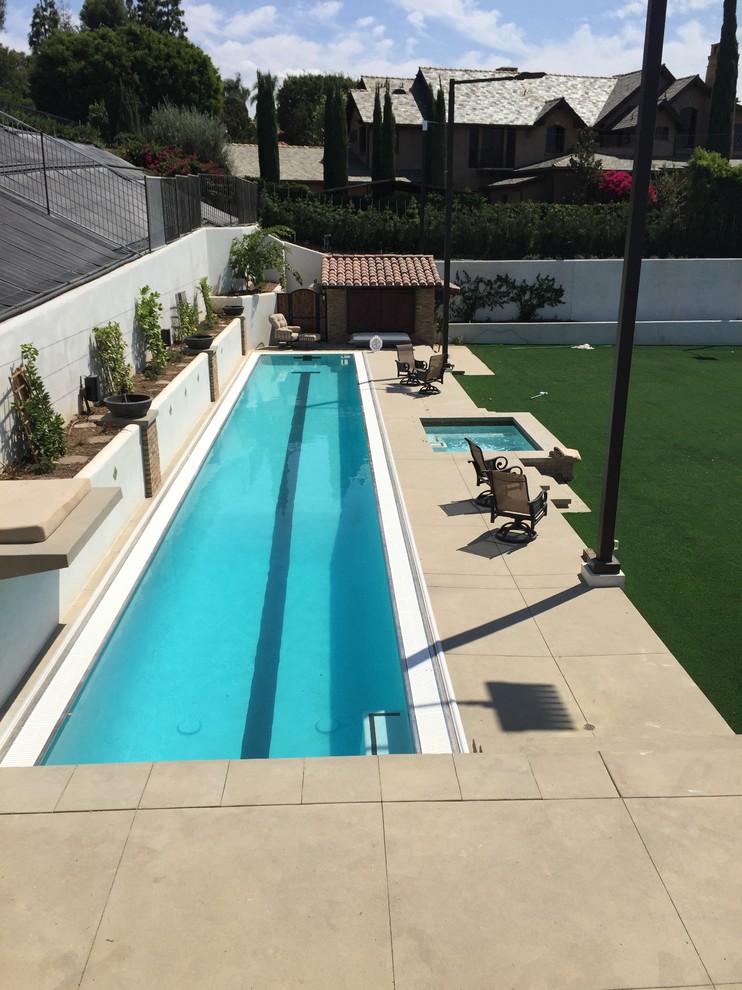Imagen de piscinas y jacuzzis alargados tradicionales extra grandes rectangulares en patio trasero con losas de hormigón