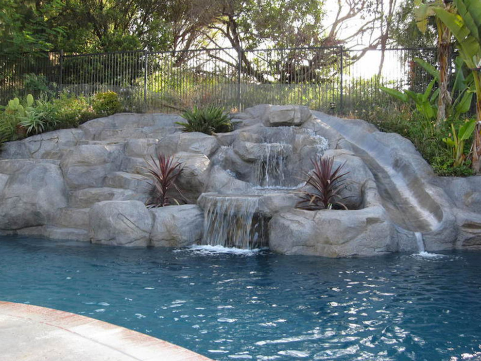 Ispirazione per una grande piscina monocorsia chic personalizzata dietro casa con pavimentazioni in cemento e un acquascivolo
