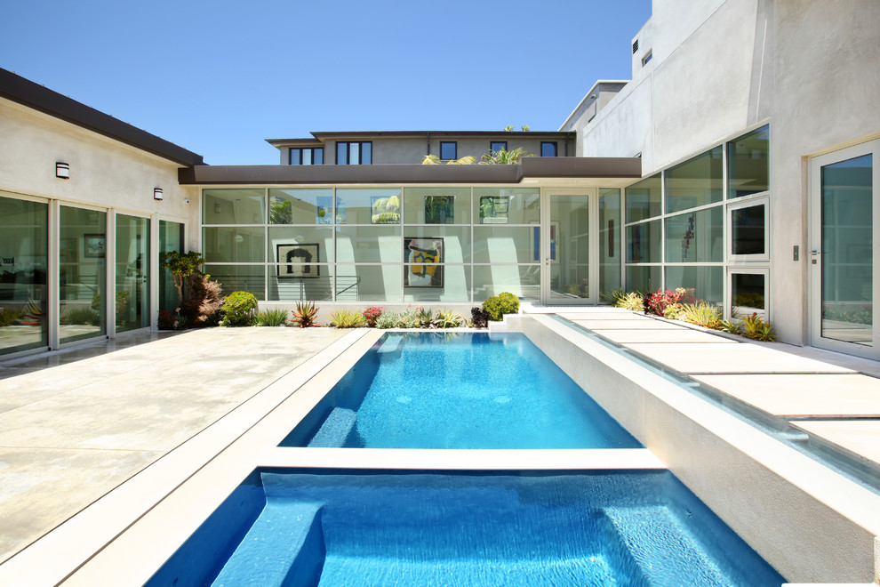 На фото: прямоугольный бассейн в современном стиле с покрытием из бетонных плит с
