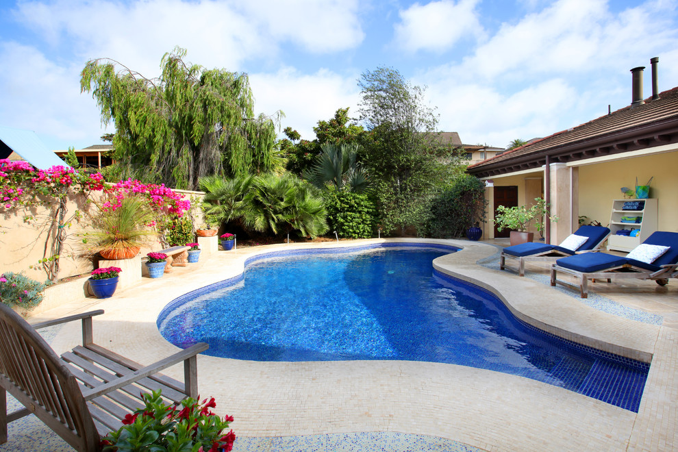 На фото: бассейн произвольной формы на заднем дворе в средиземноморском стиле с
