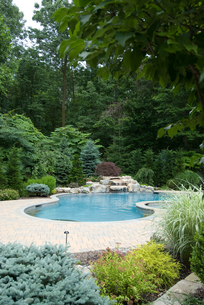 Свежая идея для дизайна: естественный бассейн среднего размера, в форме фасоли на заднем дворе в классическом стиле с фонтаном и настилом - отличное фото интерьера