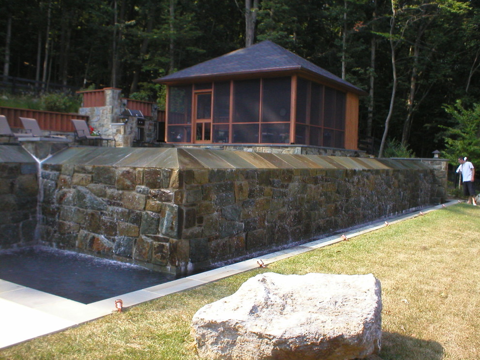 Diseño de piscina infinita de estilo americano en patio trasero con adoquines de piedra natural