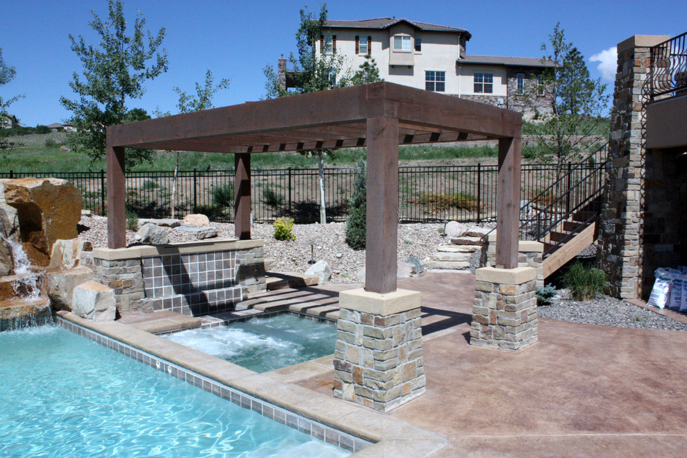 Ejemplo de piscina con tobogán alargada contemporánea grande rectangular en patio trasero con suelo de hormigón estampado
