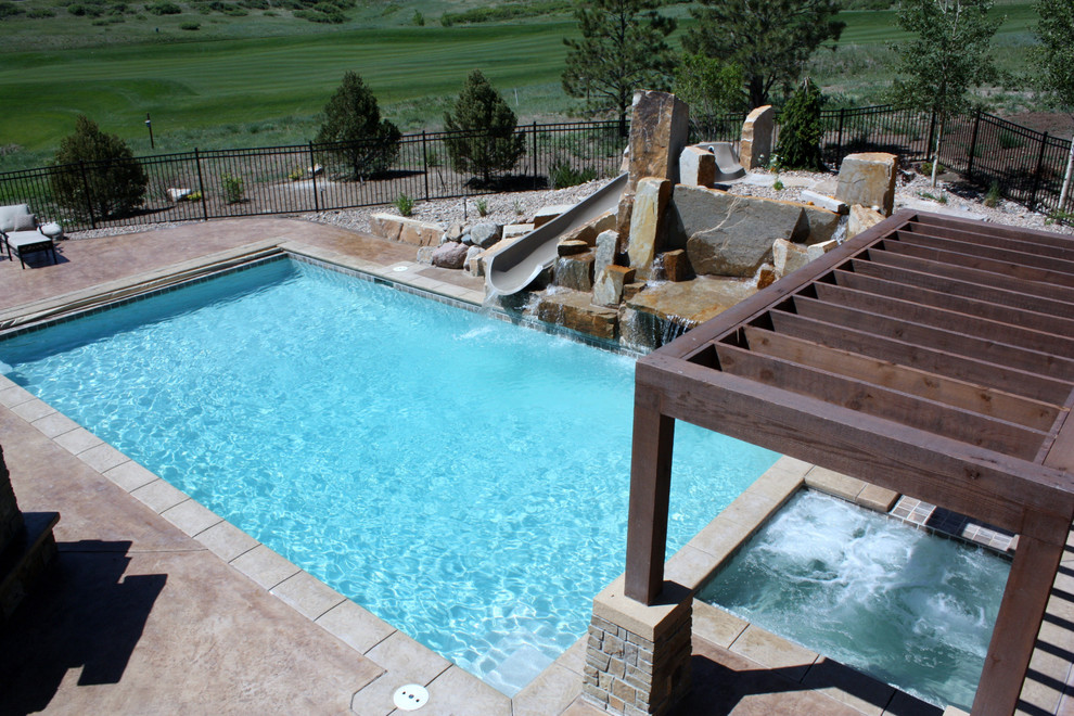 Idee per una grande piscina monocorsia contemporanea rettangolare dietro casa con un acquascivolo e cemento stampato
