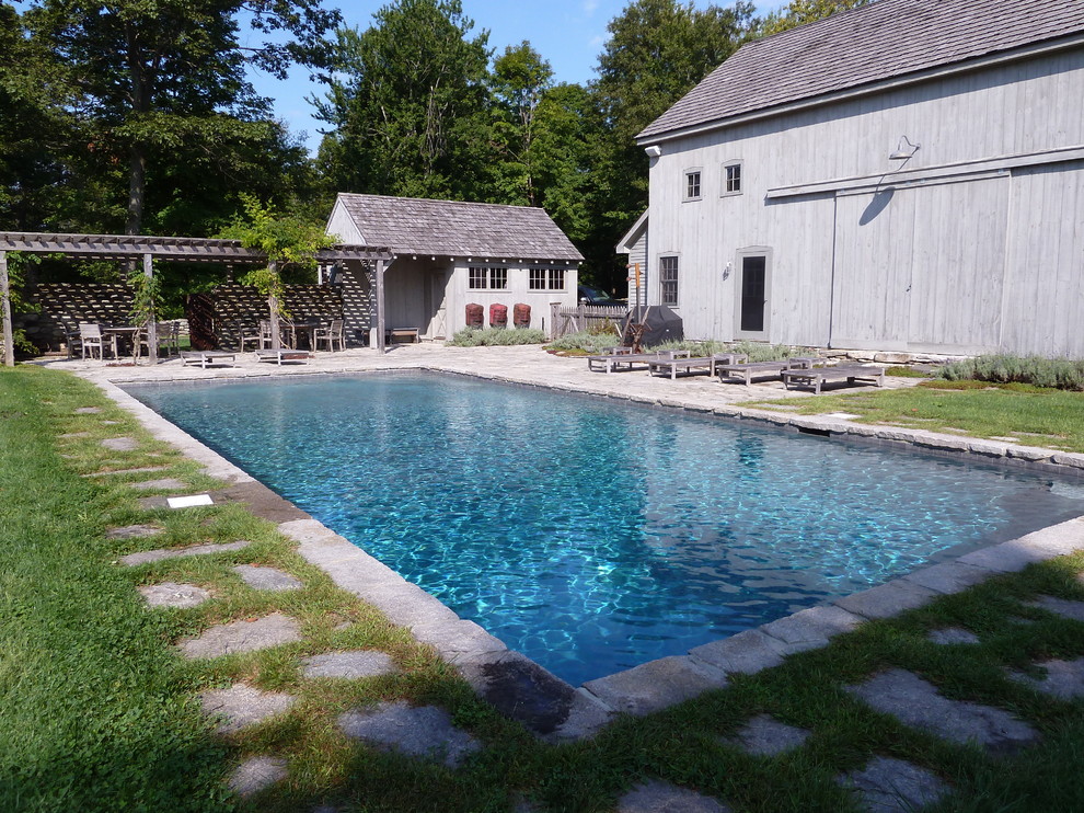 На фото: большой естественный, прямоугольный бассейн на заднем дворе в стиле кантри с покрытием из каменной брусчатки с