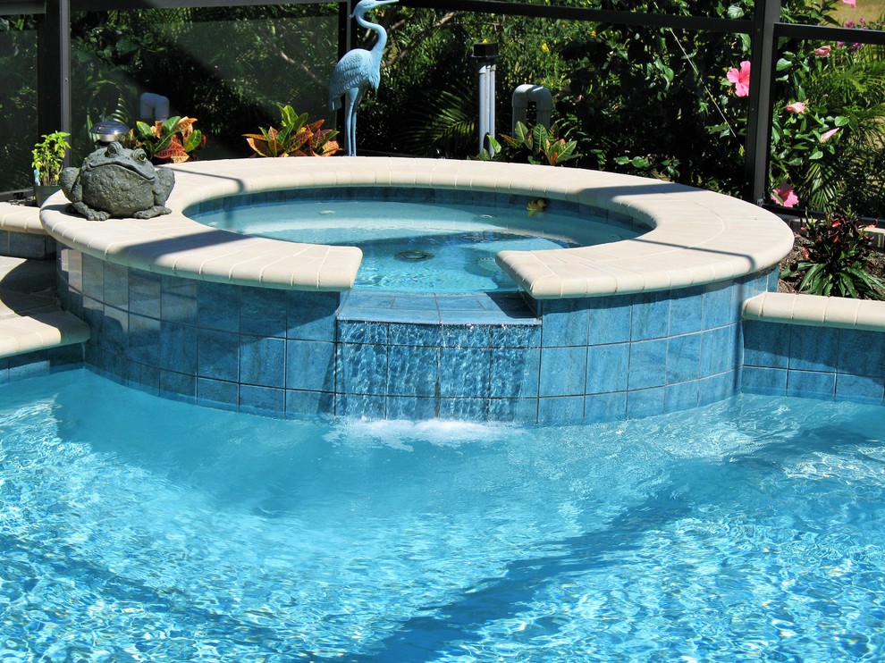Ejemplo de piscina con fuente natural moderna grande redondeada en patio trasero