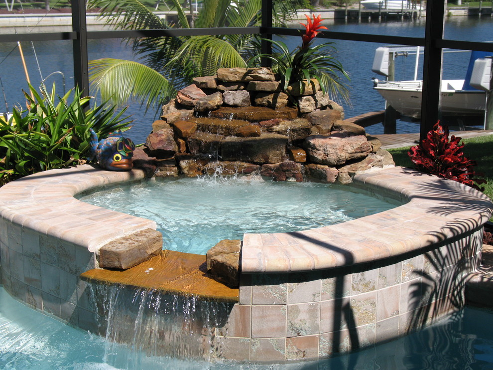 Foto de piscina con fuente natural minimalista grande redondeada en patio trasero