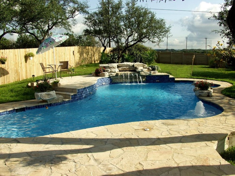 Immagine di una piscina dietro casa con fontane