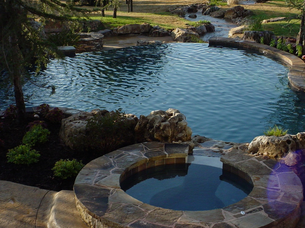 This is an example of a rustic back swimming pool in Oklahoma City.