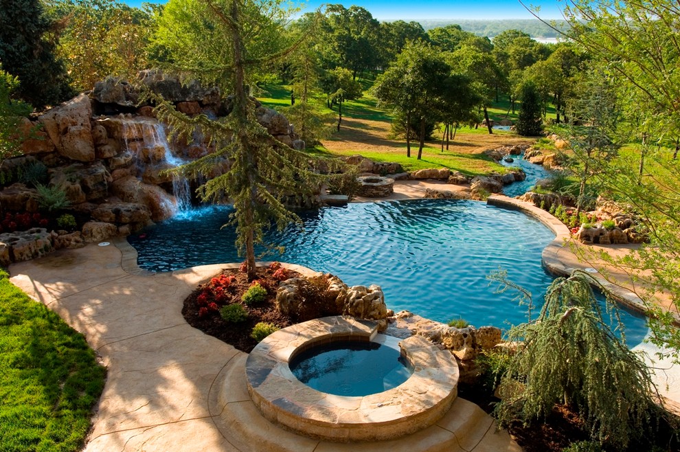 Foto di una grande piscina naturale rustica personalizzata dietro casa con una vasca idromassaggio e cemento stampato