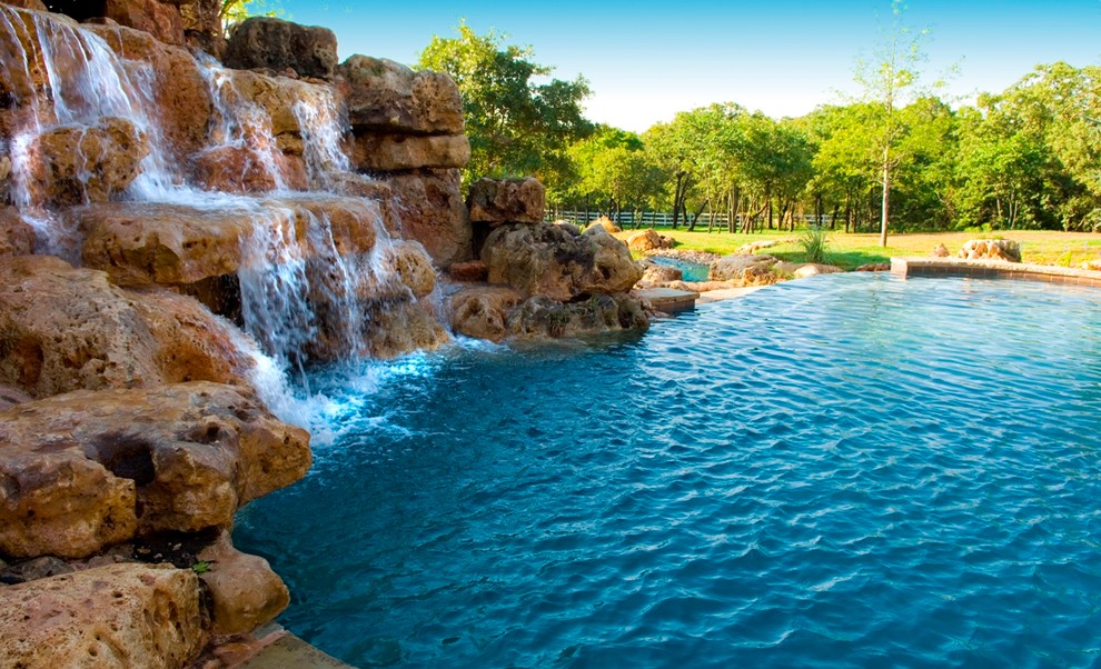 Foto de piscina con fuente natural rural grande a medida en patio trasero con adoquines de piedra natural