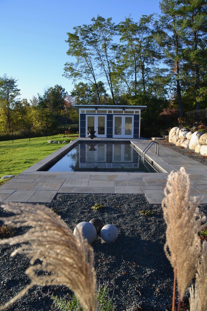 Idéer för en mellanstor modern pool på baksidan av huset, med poolhus och naturstensplattor