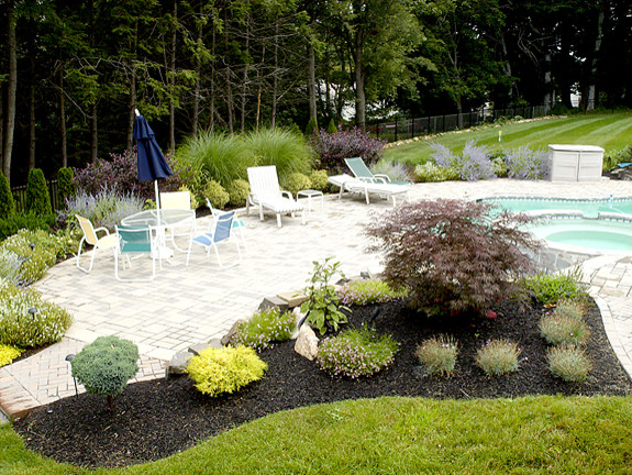 Inspiration for a large timeless backyard concrete and custom-shaped lap pool remodel in Philadelphia