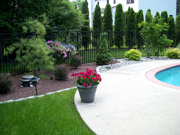 Diseño de piscina alargada tradicional de tamaño medio a medida en patio trasero con losas de hormigón