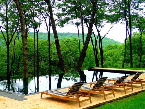 Idée de décoration pour un piscine avec aménagement paysager design avec des pavés en pierre naturelle.