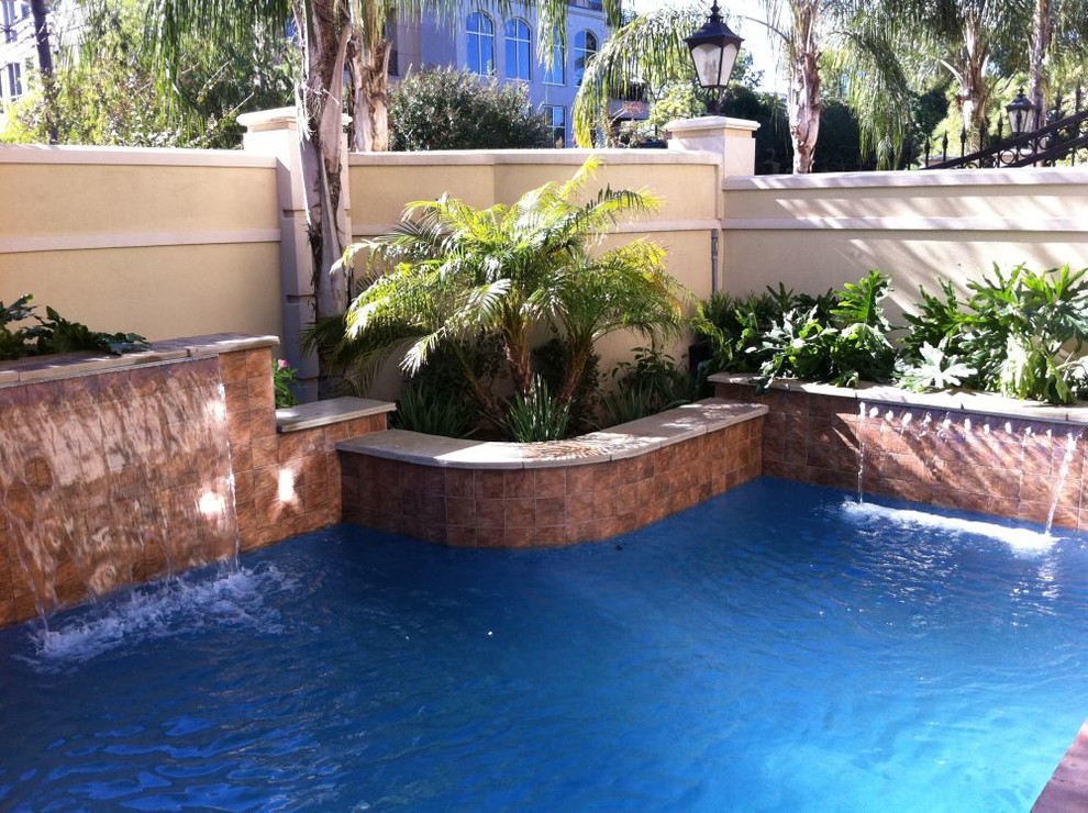 Inspiration pour une piscine arrière traditionnelle de taille moyenne et rectangle avec un point d'eau et des pavés en pierre naturelle.
