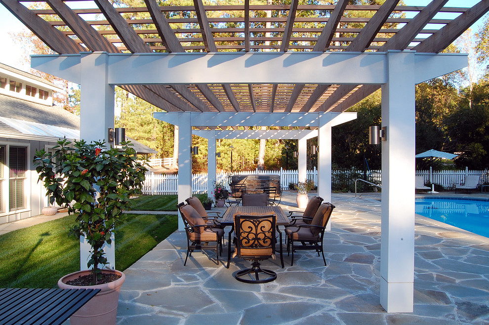 Immagine di un grande patio o portico chic nel cortile laterale con pavimentazioni in pietra naturale