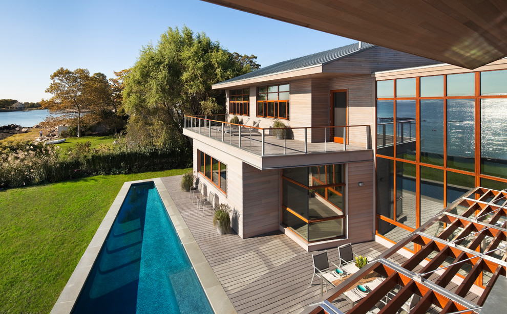 Foto di una grande piscina monocorsia minimalista rettangolare dietro casa con pavimentazioni in pietra naturale