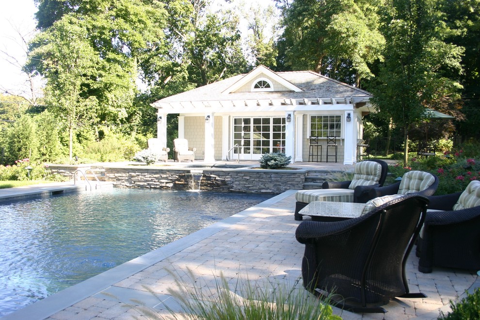 Foto di una grande piscina monocorsia american style rettangolare dietro casa con una dépendance a bordo piscina e pavimentazioni in pietra naturale