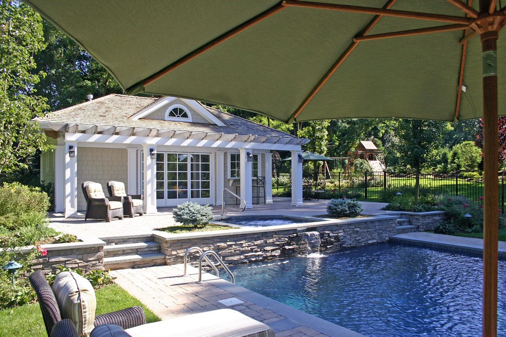 Imagen de piscinas y jacuzzis alargados de estilo americano grandes rectangulares en patio trasero con adoquines de piedra natural