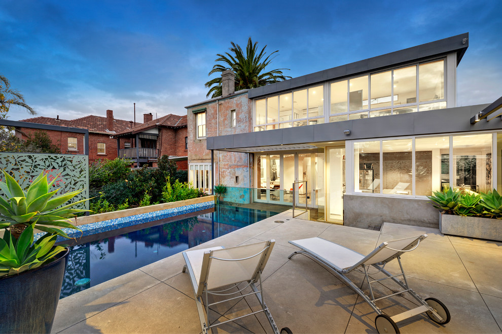 Photo of a medium sized contemporary back rectangular swimming pool in Melbourne with concrete slabs.