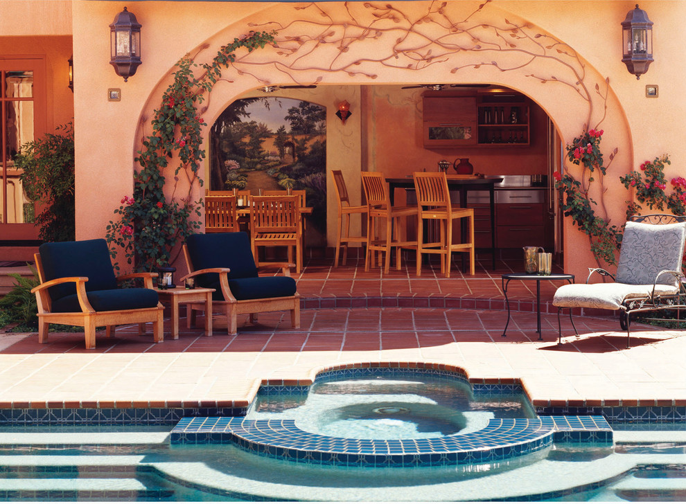 Пример оригинального дизайна: прямоугольный бассейн среднего размера на заднем дворе в средиземноморском стиле с джакузи и покрытием из плитки