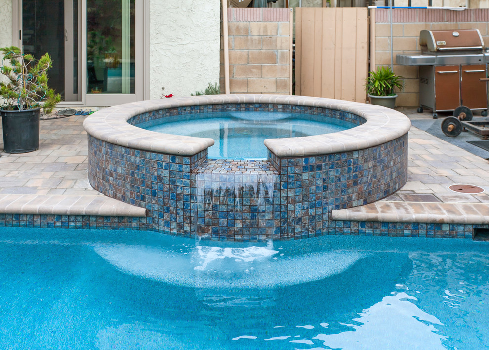Esempio di una piscina monocorsia classica rettangolare di medie dimensioni e dietro casa con una vasca idromassaggio e pavimentazioni in cemento
