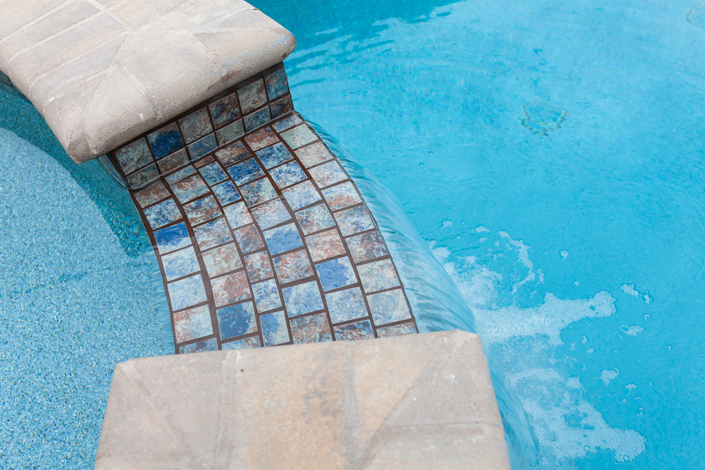 Foto de piscinas y jacuzzis alargados tradicionales de tamaño medio rectangulares en patio trasero con adoquines de hormigón