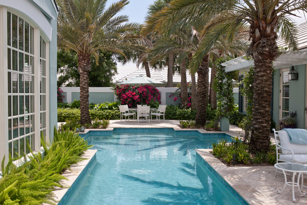Diseño de casa de la piscina y piscina alargada tropical de tamaño medio a medida con suelo de baldosas