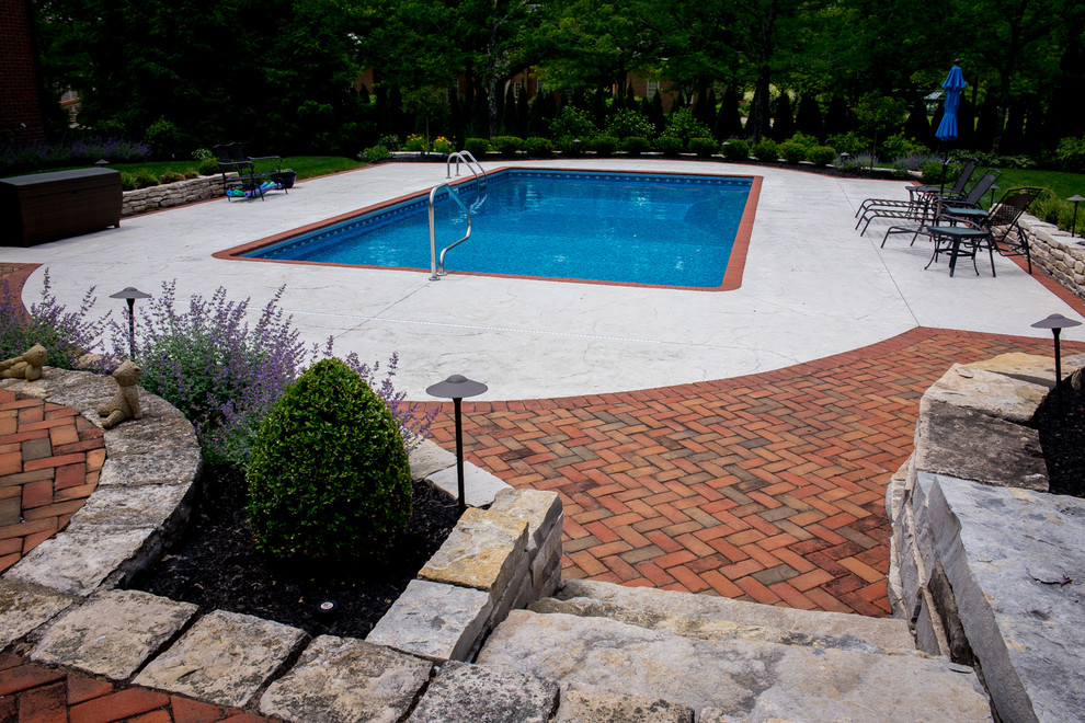 Esempio di una grande piscina monocorsia chic rettangolare dietro casa con cemento stampato