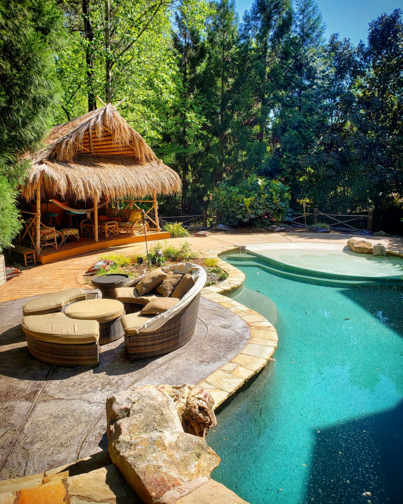 Diseño de casa de la piscina y piscina natural exótica pequeña a medida en patio trasero con adoquines de piedra natural