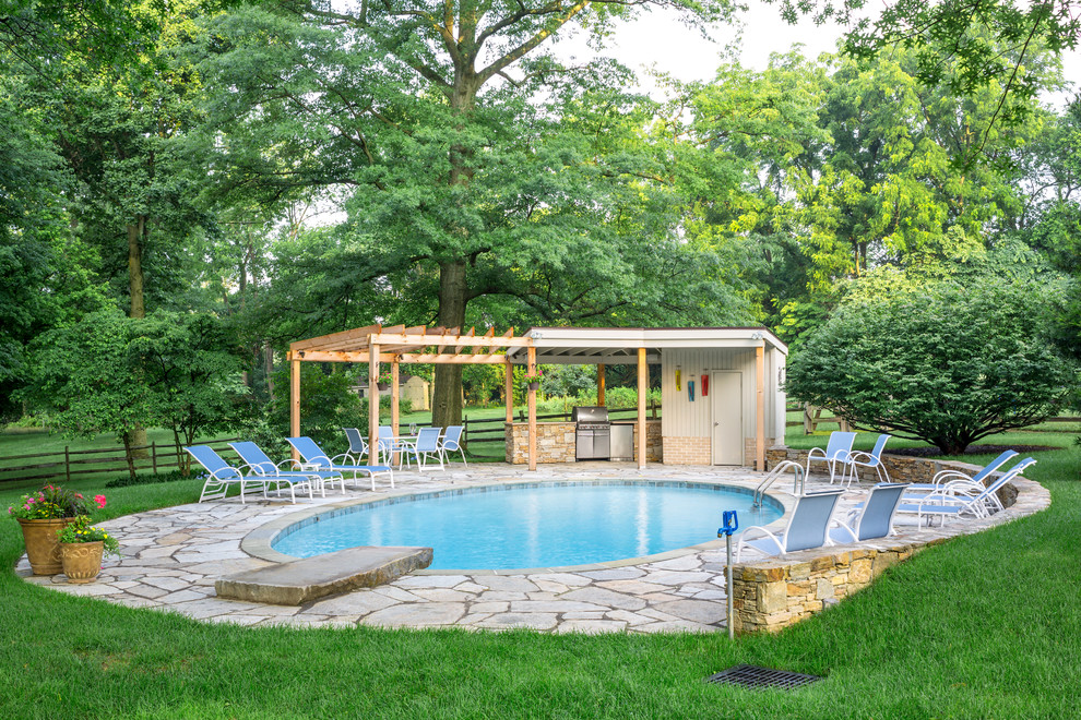 Diseño de casa de la piscina y piscina alargada contemporánea redondeada en patio trasero con adoquines de piedra natural