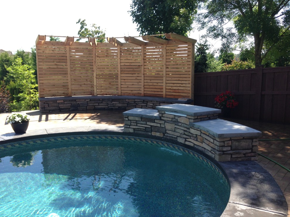Imagen de piscina con fuente alargada clásica renovada de tamaño medio a medida en patio trasero con adoquines de ladrillo
