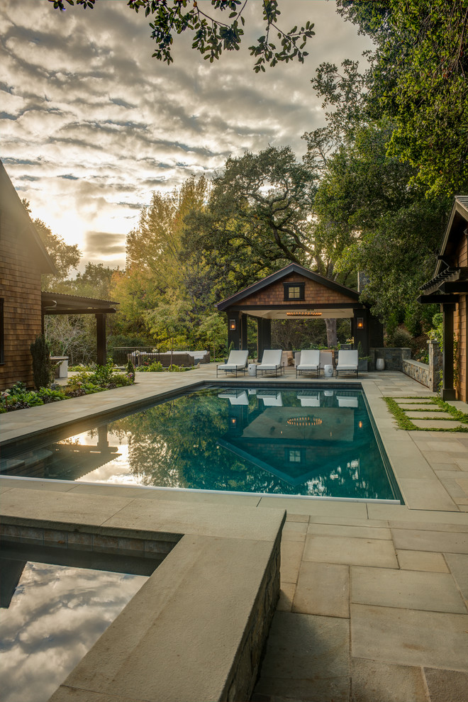 Idee per un'ampia piscina monocorsia chic rettangolare nel cortile laterale con pavimentazioni in pietra naturale