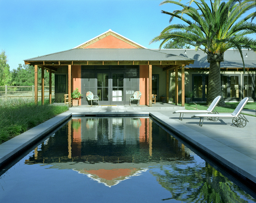 Imagen de piscina de estilo de casa de campo rectangular con losas de hormigón