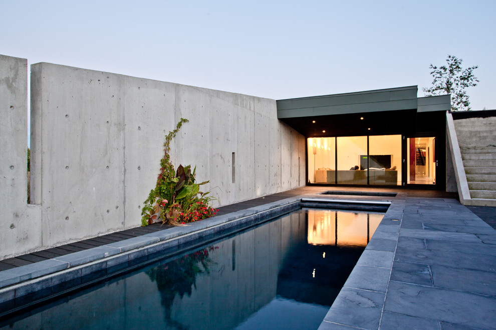 Diseño de piscinas y jacuzzis alargados modernos grandes rectangulares en patio lateral con adoquines de piedra natural