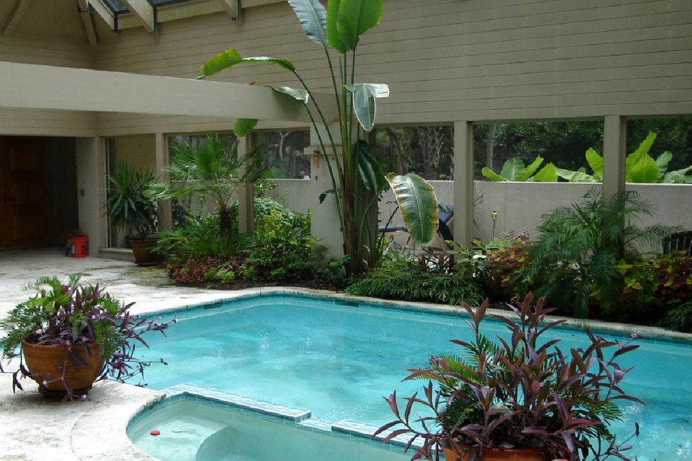 Пример оригинального дизайна: прямоугольный бассейн в доме в стиле неоклассика (современная классика) с джакузи и покрытием из декоративного бетона