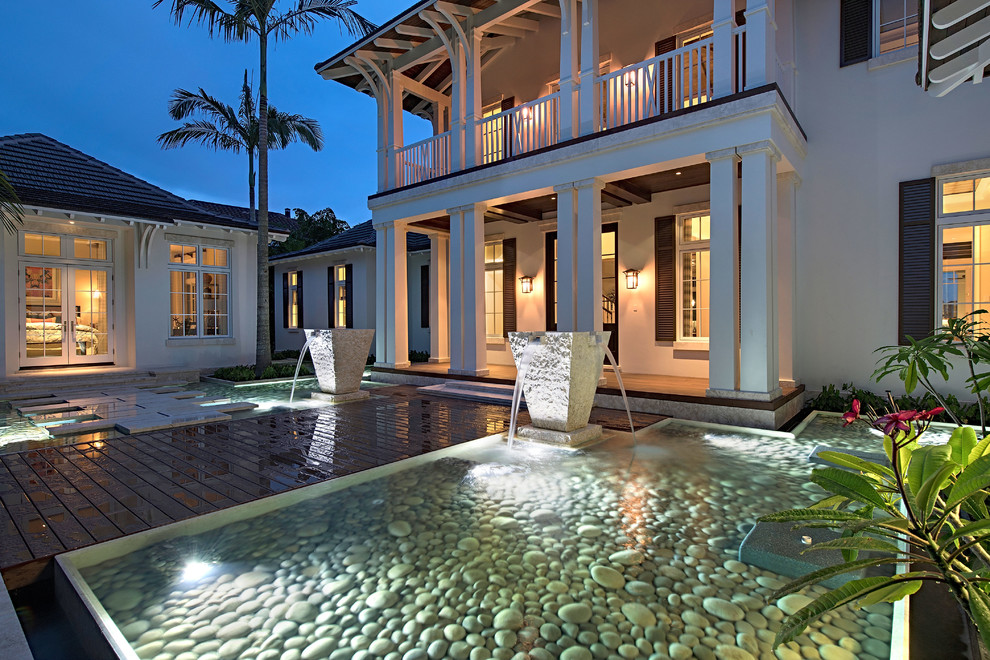 マイアミにあるラグジュアリーな巨大なアジアンスタイルのおしゃれな前庭プール (噴水、天然石敷き) の写真