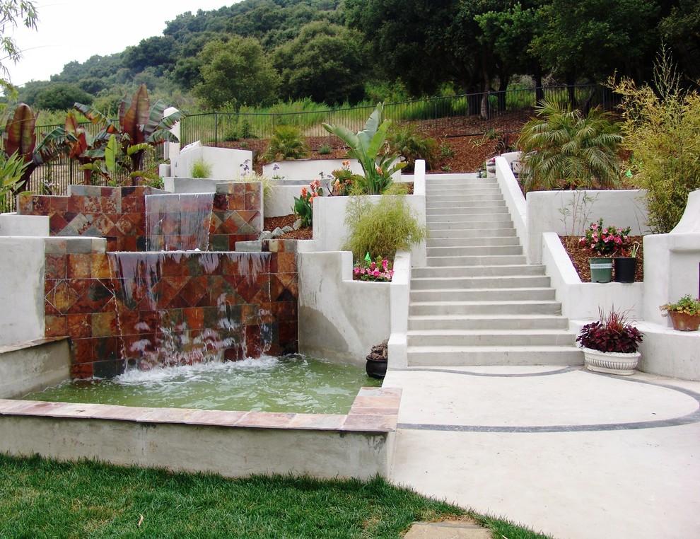 Inspiration for a large contemporary back rectangular swimming pool in San Luis Obispo with a water feature and concrete slabs.