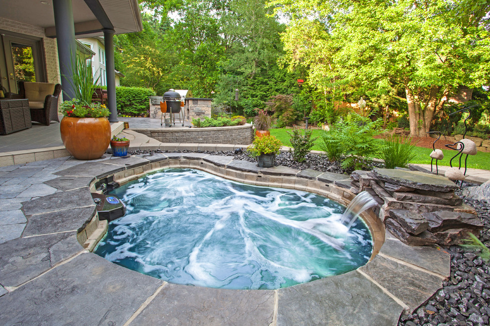 На фото: бассейн на заднем дворе в классическом стиле с покрытием из каменной брусчатки и зоной барбекю с