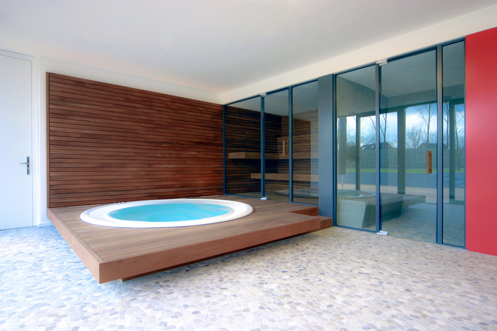 Пример оригинального дизайна: маленький круглый бассейн в доме в современном стиле с джакузи и покрытием из каменной брусчатки для на участке и в саду