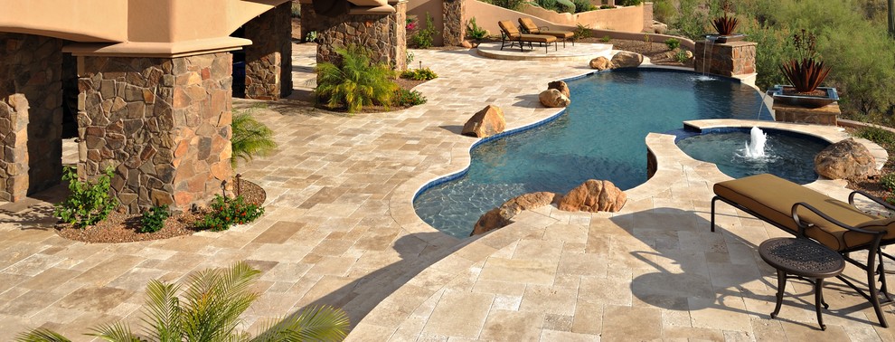 Diseño de piscinas y jacuzzis infinitos mediterráneos grandes a medida en patio trasero con suelo de hormigón estampado
