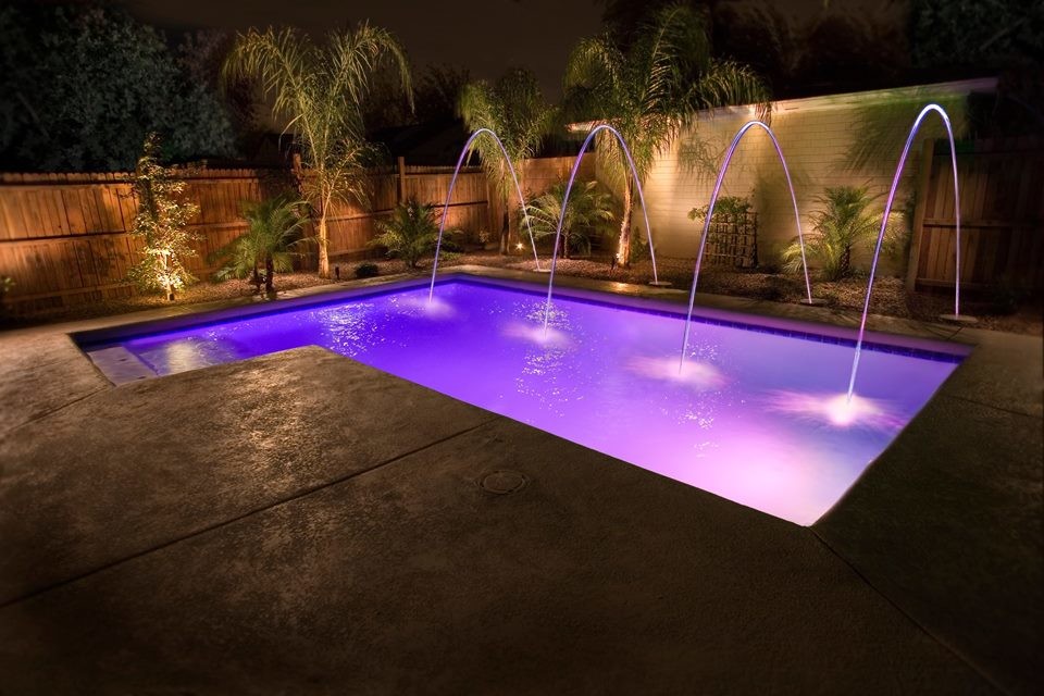 Inspiration for a medium sized contemporary back custom shaped natural swimming pool in Phoenix with natural stone paving.