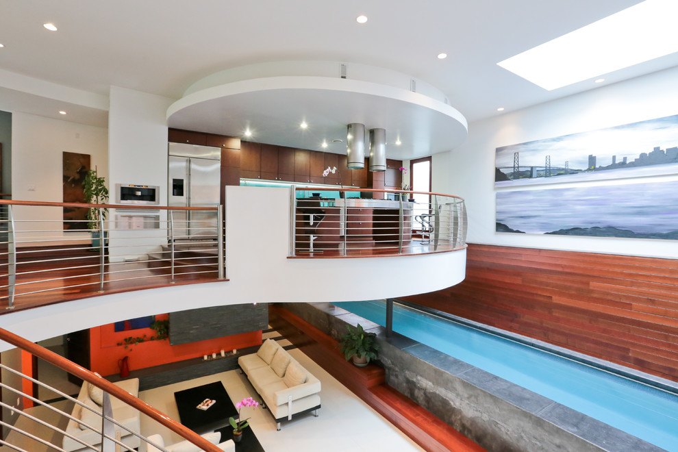 Photo of a large modern indoor rectangular lengths swimming pool in San Francisco with a pool house and concrete slabs.