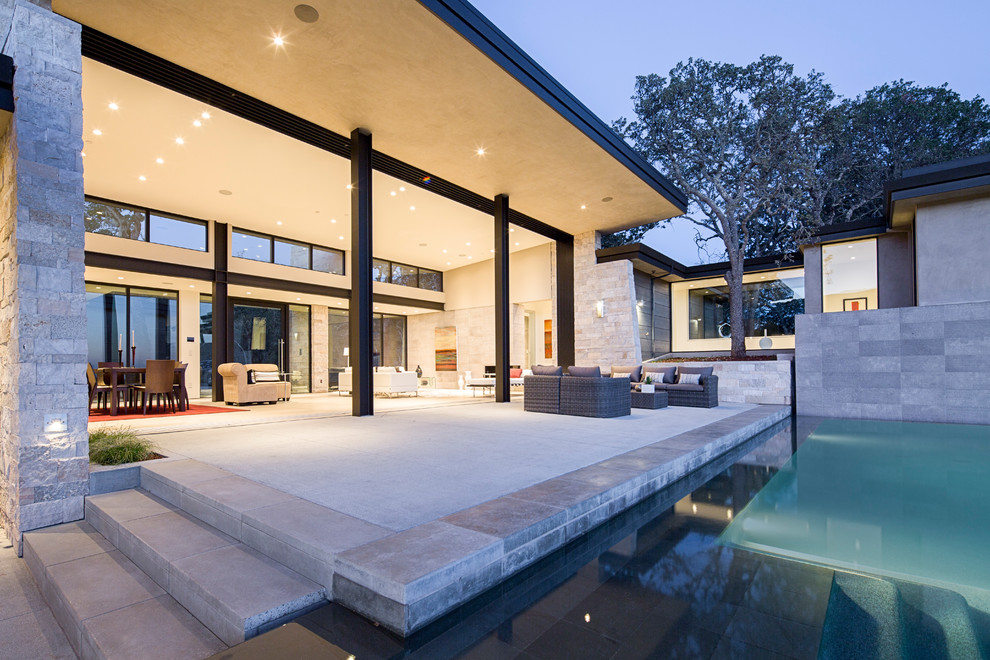Diseño de piscina con fuente infinita actual extra grande rectangular en patio con adoquines de piedra natural