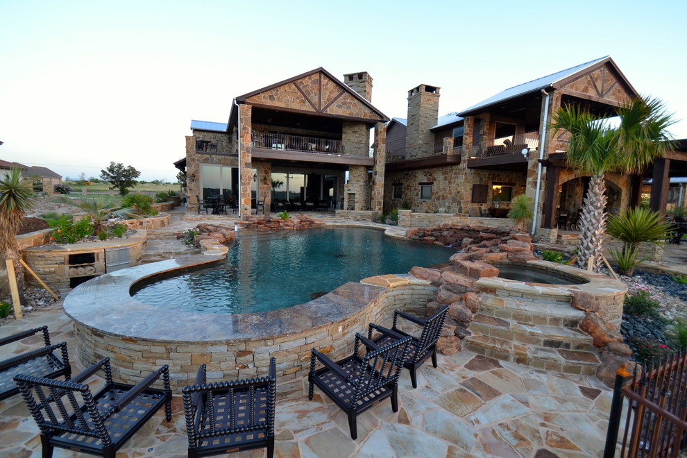 Esempio di una grande piscina rustica personalizzata dietro casa con pavimentazioni in pietra naturale