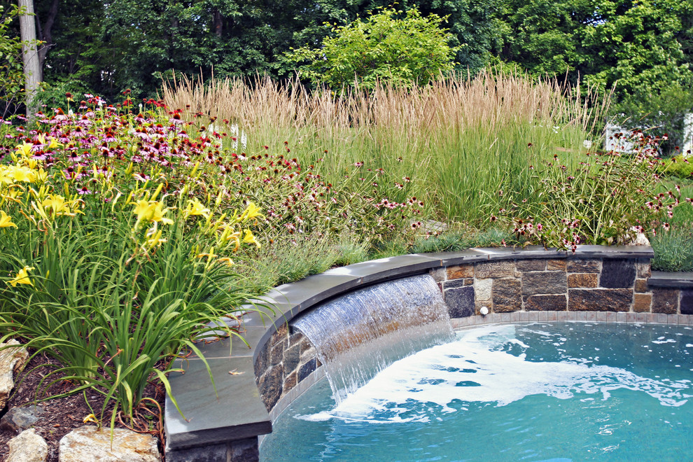Großer Country Pool hinter dem Haus in runder Form mit Natursteinplatten in New York