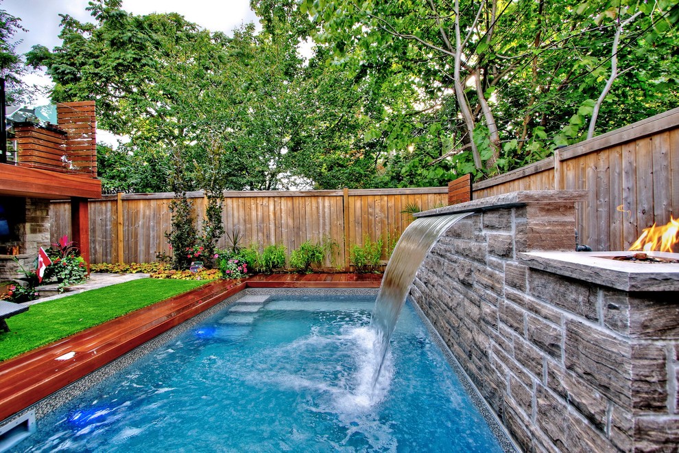 На фото: маленький прямоугольный бассейн на заднем дворе в стиле неоклассика (современная классика) с фонтаном и настилом для на участке и в саду