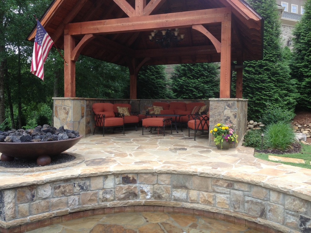 Immagine di un ampio patio o portico tradizionale dietro casa con pavimentazioni in pietra naturale